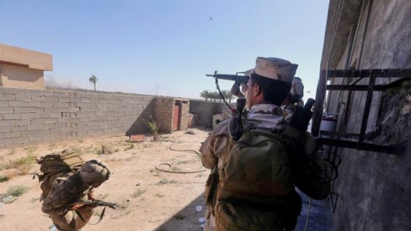 In this Sunday, April 26, 2015 photo, Iraqi security forces clash with Islamic State group militants, during an operation to retake the water control station on a canal lost over the weekend, in the town of Garma, between Baghdad and the Islamic State-held city of Fallujah, Iraq. Defense Minister Khalid al-Obeidi said on Iraqi television that the army has achieved "90 percent" of its objectives in the town of Garma. (AP Photo)