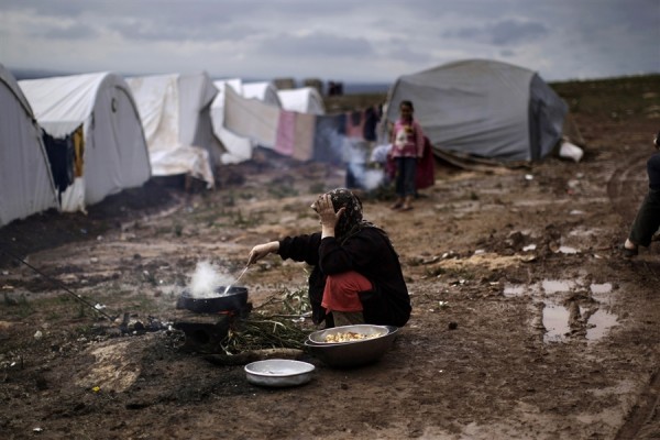 لاجئة سورية تعد الطعام امام خيمتها في مخيم للاجئين AP