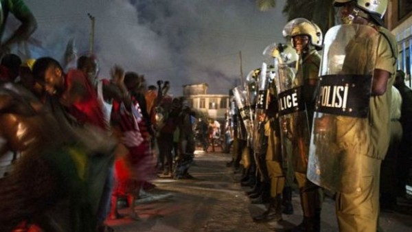 قوات مكافحة الشغب التنزانية تقف أمام متظاهرين يحتفلون بإعلان فوز مرشح ائتلاف الجبهة المدنية المتحدة، مولد متوليا، بانتخابات دائرة كينوندوني في دار السلام. كانت الانتخابات العامة في تنزانيا الأكثر ضراوةً من حيث التنافس منذ الاستقلال عام 1961. 