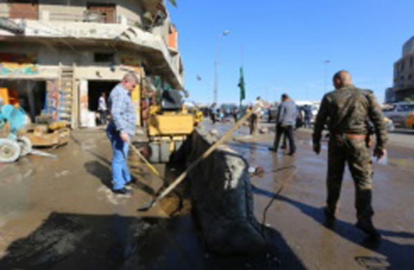afp.com / / صباح عرار عراقيون يقومون بتنظيف موقع هجوم في ساحة الطيران في بغداد، في 29 آذار/مارس 2016 