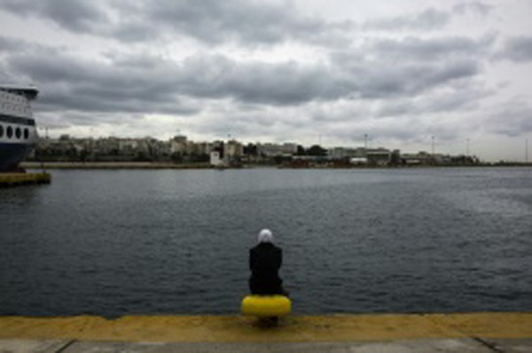 afp.com / / انجيلوس جورجينيس - مهاجرة تجلس في مرفأ بيرايوس اليوناني في اثينا 12 مارس 2016 