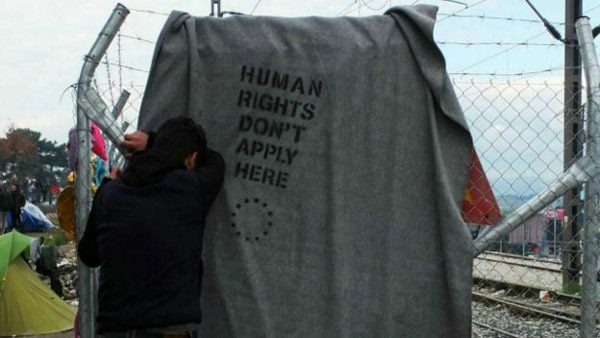 مخيم إيدوميني، الجملة المطبوعة على البطانية تقول: "حقوق الإنسان لا تطبق هنا" 
