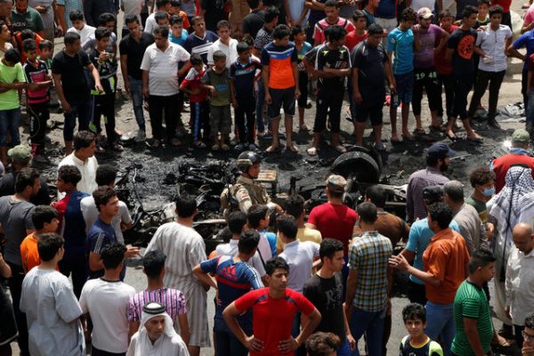 People gather at the scene of a car bomb attack in Baghdad's mainly Shi'ite district of Sadr City