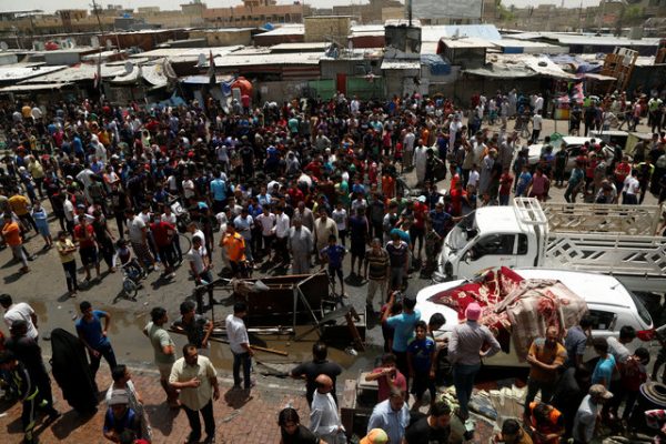 People gather at the scene of a car bomb attack in Baghdad's mainly Shi'ite district of Sadr City