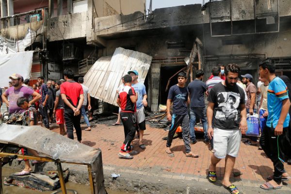 People gather at the scene of a car bomb attack in Baghdad's mainly Shi'ite district of Sadr City