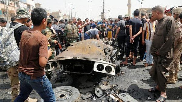 People gather at the scene of a car bomb attack in Baghdad's mainly Shi'ite district of Sadr City