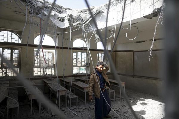 طفل يمني يقف في أحد الصفوف بمدرسته بعد تعرضها للقصف من قبل التحالف العربي بقيادة السعودية بضربة جوية للعاصمة اليمنية صنعاء في 20 تموز 2015. (رويترز)
