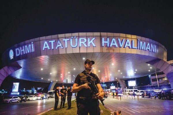 TOPSHOT - A Turkish riot police officer patrols Ataturk airport`s main enterance in Istanbul, on June 28, 2016, after two explosions followed by gunfire hit Turkey's largest airport, killing at least 10 people and injuring 20.  All flights at Istanbul's Ataturk international airport were suspended on June 28, 2016 after a suicide attack left at least 36 people dead.  / AFP PHOTO / OZAN KOSE