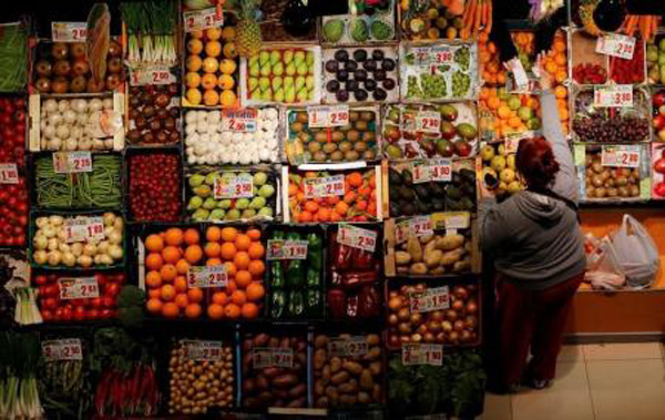 امرأة تشتري فاكهة وخضروات في سوق في أشبيلية بجنوب اسبانيا يوم 7 مارس اذار 2016 - رويترز 