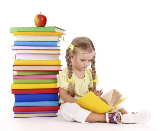 Child reading  pile of books.