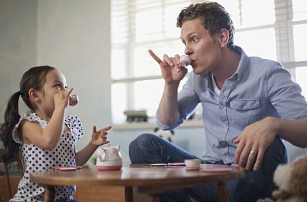 Father and young daughter having a tea party.