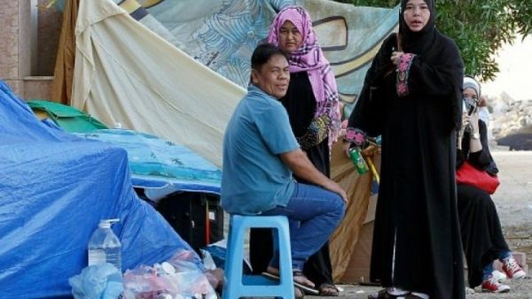 © أ ف ب | عمال فيليبينيون في خيمة في قنصلية بلادهم في جدة 