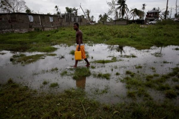 A man carries a water as he walks in a flooded area after Hurricane Matthew in Les Cayes, Haiti, October 6, 2016. REUTERS/Andres Martinez Casares