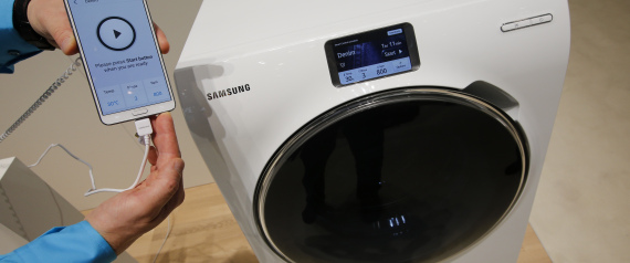 A Samsung employee holds a smartphone remotely controlling a WW9000 washing machine at the IFA consumer technology fair in Berlin
