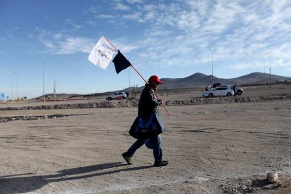 A worker from Escondida, the world's biggest copper mine, walks outside the company gates, in Antofagasta